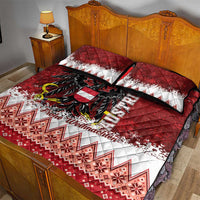 Red quilt and two pillowcases with black eagle graphic and white snowflake Nordic stripes