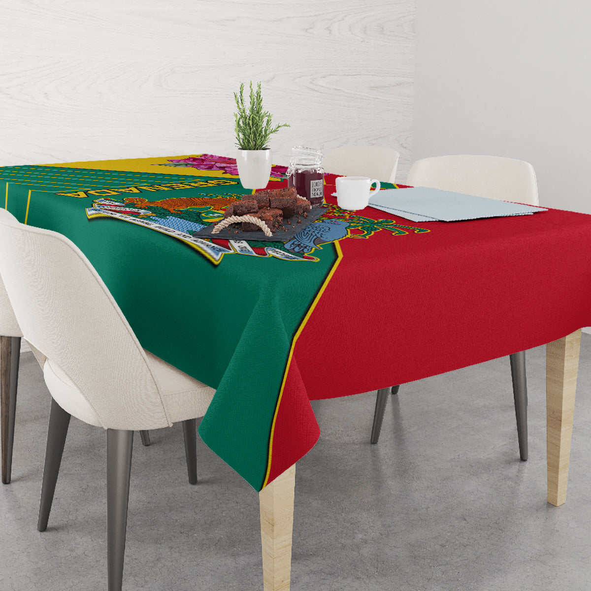 Green and red tablecloth with Grenada emblem and decorative border on dining table