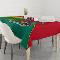 Green and red tablecloth with Grenada emblem and decorative border on dining table