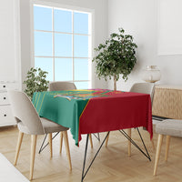 Green and red tablecloth with Grenada emblem on dining table with four chairs