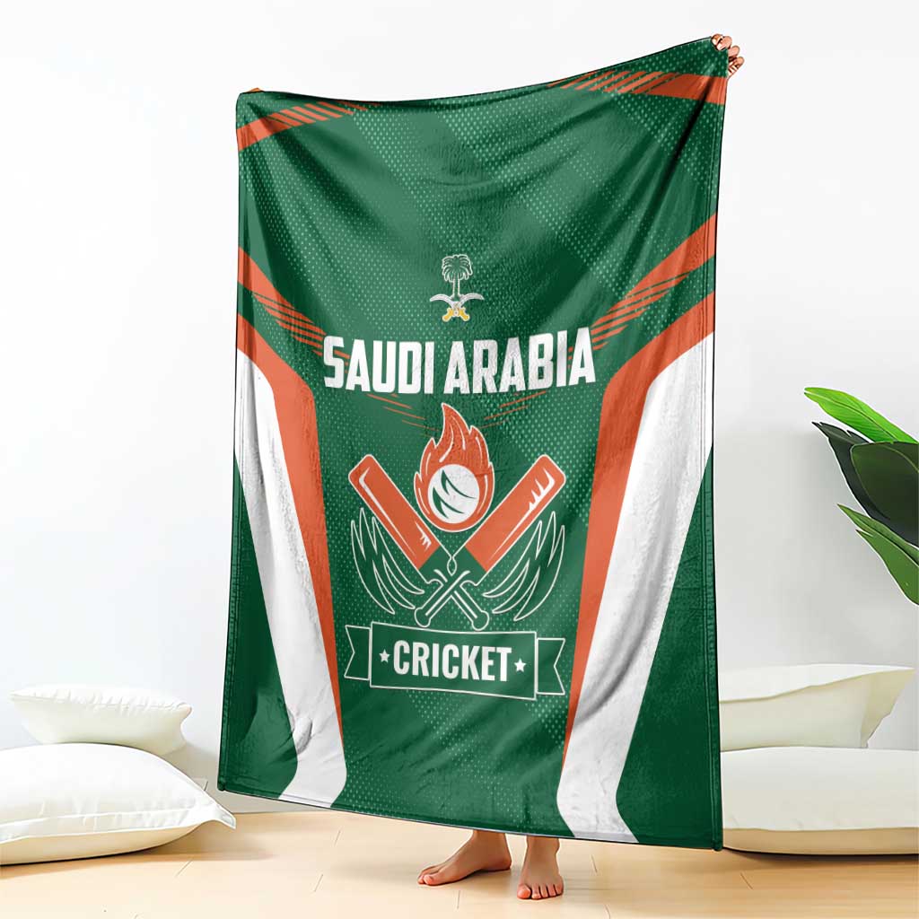 Green cricket blanket with white and orange design panels, draped on bed with barefoot edge