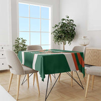 Green cricket tablecloth with white and orange accents on dining table