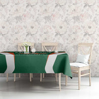 Green cricket tablecloth with white stripes and crest, draped across dining table