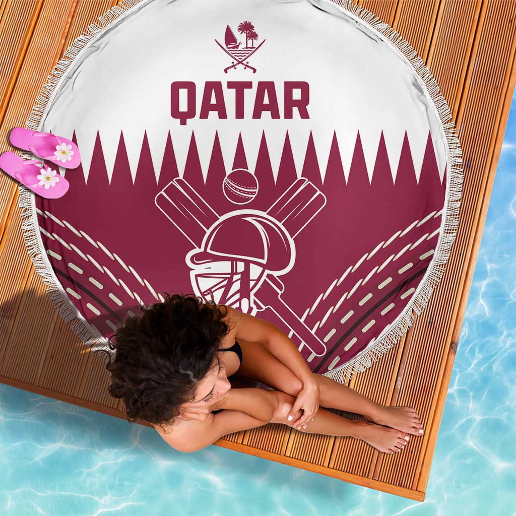 Round beach blanket with Qatar text and maroon cricket emblem, fringed edge by pool
