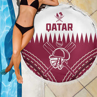 Round beach blanket with Qatar text and maroon cricket helmet emblem, fringed border