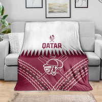 Qatar cricket blanket on gray sofa, maroon field pattern with batting player