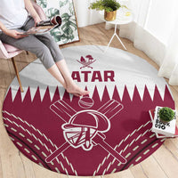 Red round cricket carpet with white Qatar logo and maroon bat and helmet graphic