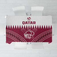 Folded red tablecloth featuring Qatar cricket emblem and white geometric rays