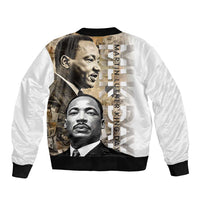 White unisex bomber jacket with black rib trim; large MLK collage and vertical text back