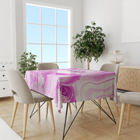 Purple floral swirls tablecloth draped over a dining table with chairs