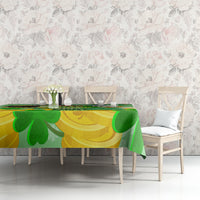 Green and gold shamrock tablecloth on table with clover motif, set for dining