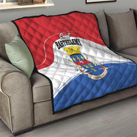 Red, white, and blue quilt blanket on a sofa featuring Saint Barthelemy crest
