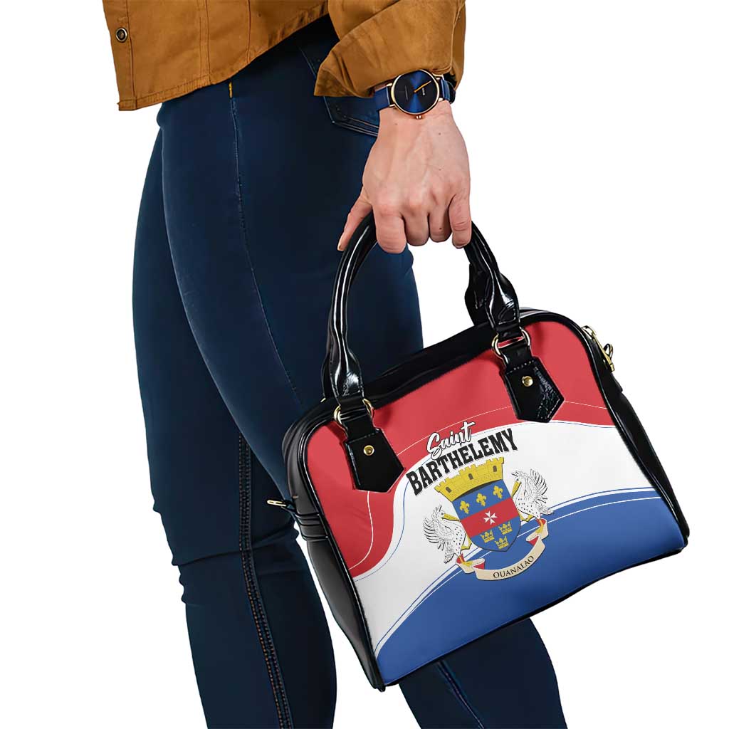 Shoulder handbag on woman with black handles, red top, and crest logo on front