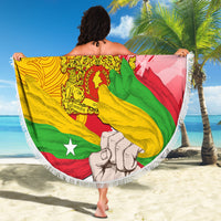 Round beach blanket with fringe edge, Myanmar flag-style graphic on sandy beach