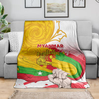 Draped Myanmar flag blanket featuring MYANMAR text, clenched fist artwork, yellow green red on white