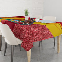 Red tablecloth with glitter texture and multicolor bands, draped over a dining table