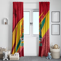 Pair of red Grenada flag window curtains with diagonal yellow-green stripes and sparkly hem.