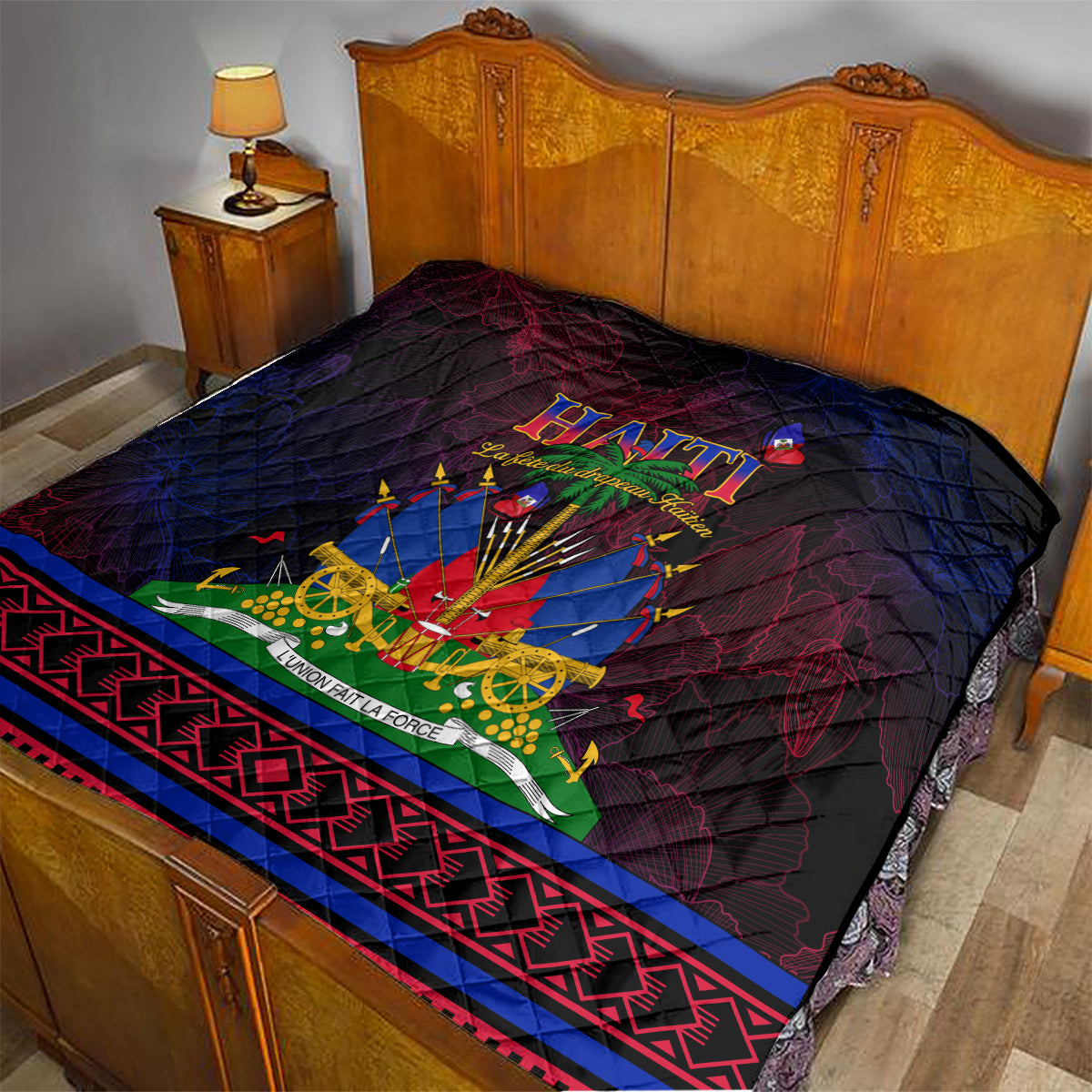 Haitian Flag Day quilt on bed with central Haiti emblem and red/blue geometric trim, dark quilted fabric.