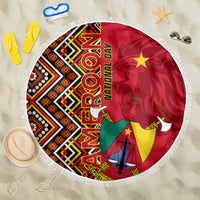 Round fringed beach blanket with Cameroon coat-of-arms amid red, green, yellow Ankara pattern