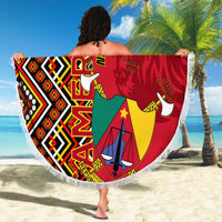 Round fringed beach blanket held out, Cameroon coat-of-arms in red, yellow, green Ankara print
