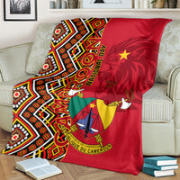 Cameroon national day blanket folded on sofa, red and multicolor Ankara pattern with coat of arms