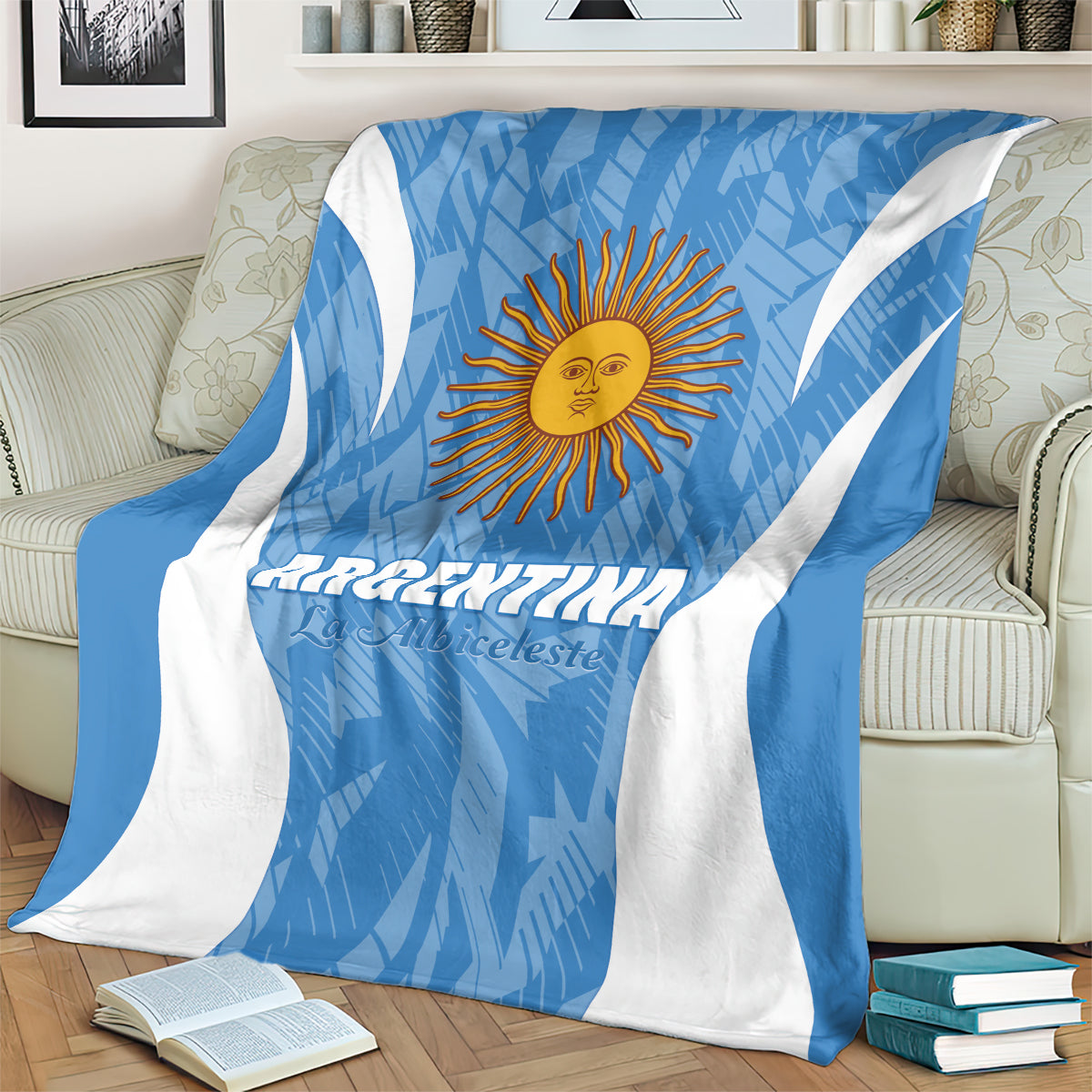 Blue and white Argentina football blanket with sun emblem, draped across beige sofa.