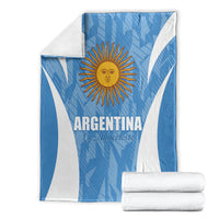 Argentina football blanket, blue with white V stripes and sun crest, with folded towels.