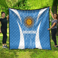 Argentina blue quilt blanket with sun emblem and white diagonal stripes, spread on grass