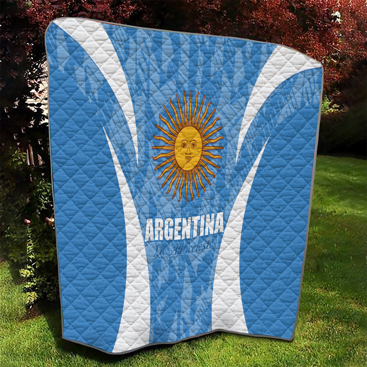 Argentina blue quilt blanket with sun emblem and white diagonal stripes, draped over furniture