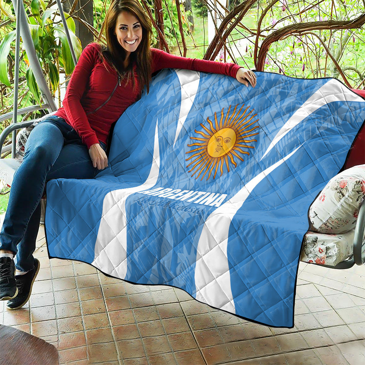 Argentina blue quilt blanket with sun emblem and white diagonal stripes, wrapped on sofa