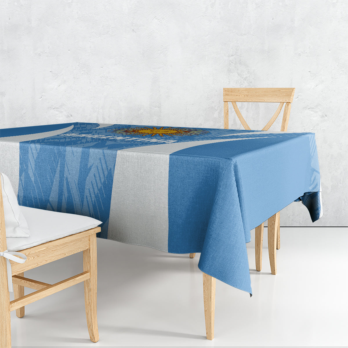 Blue Argentina-themed tablecloth with diagonal texture, draped over a rectangular dining table.