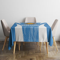 Blue tablecloth with white center stripe and sun-themed graphic, draped over dining table.