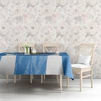 Blue tablecloth with diagonal texture and sun emblem, draped over dining table.