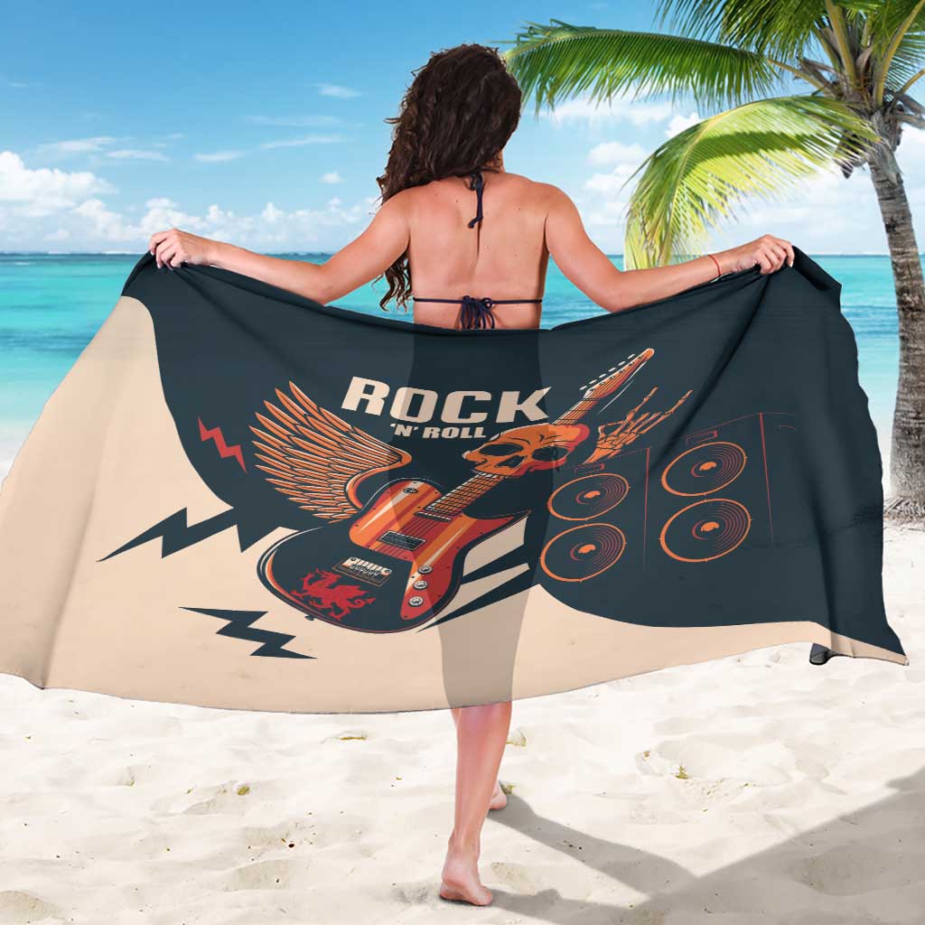 Sarong wrap with guitar and skull rock graphic, dark print with beige panels, arms stretched