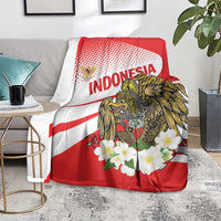 Red and white blanket with eagle graphic, 'INDONESIA' lettering, and white flower cluster