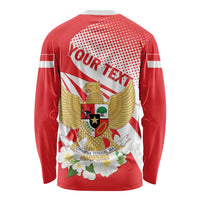 Red long-sleeve shirt with back crest, wings illustration, and white dotted circle
