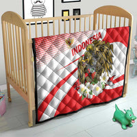 Red and white Indonesia quilt blanket with eagle graphic and flower cluster on a crib