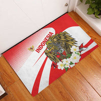 Red doormat with 'INDONESIA' lettering, gold eagle and white flower artwork