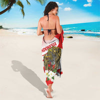 Red and white sarong wrapped on legs, with eagle and white flower details
