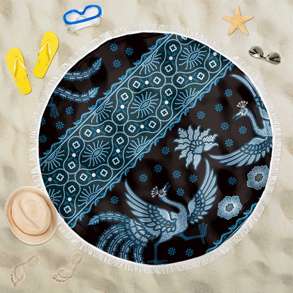 Blue batik-pattern beach blanket, round with white fringe edge and bird floral motifs.