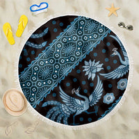 Blue batik-pattern beach blanket, round with white fringe edge and bird floral motifs.