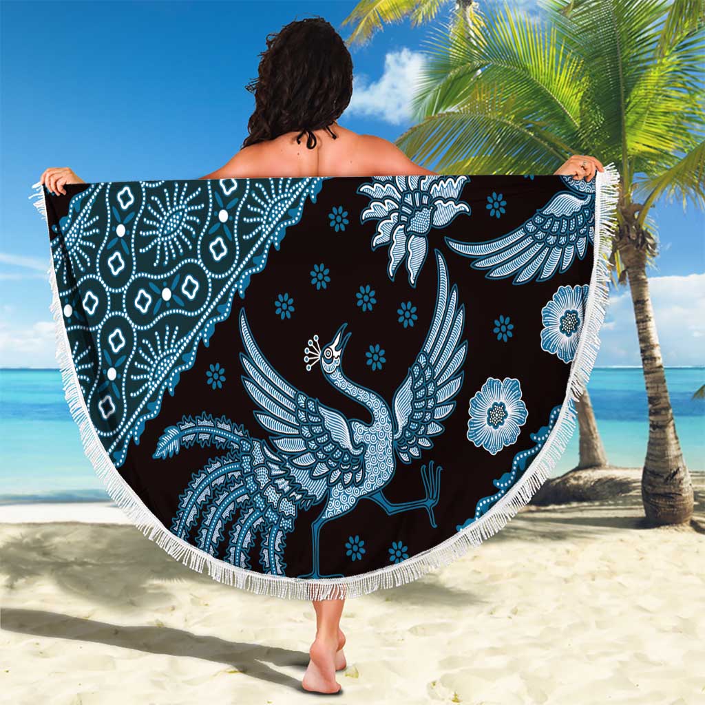 Blue batik-pattern beach blanket with white fringe edge, round bird and blossom design.