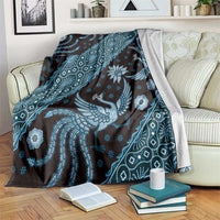 Blue batik-pattern blanket draped over sofa, bird and floral motifs with geometric accents
