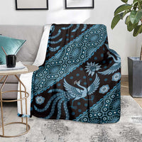 Blue batik-pattern blanket over armchair, bird and flower motifs with diamond accents