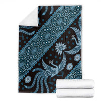 Blue batik-pattern blanket with bird and floral motifs, folded with visible trim