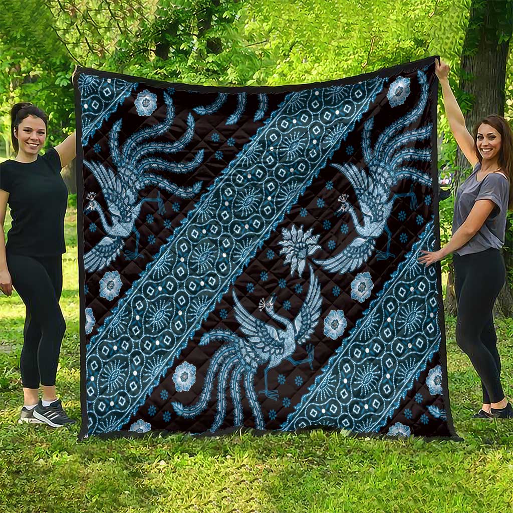 Blue batik pattern quilt hanging outdoors with dragon scrolls and floral details