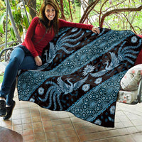Blue batik pattern quilt spread out, featuring dragon silhouettes and floral shapes