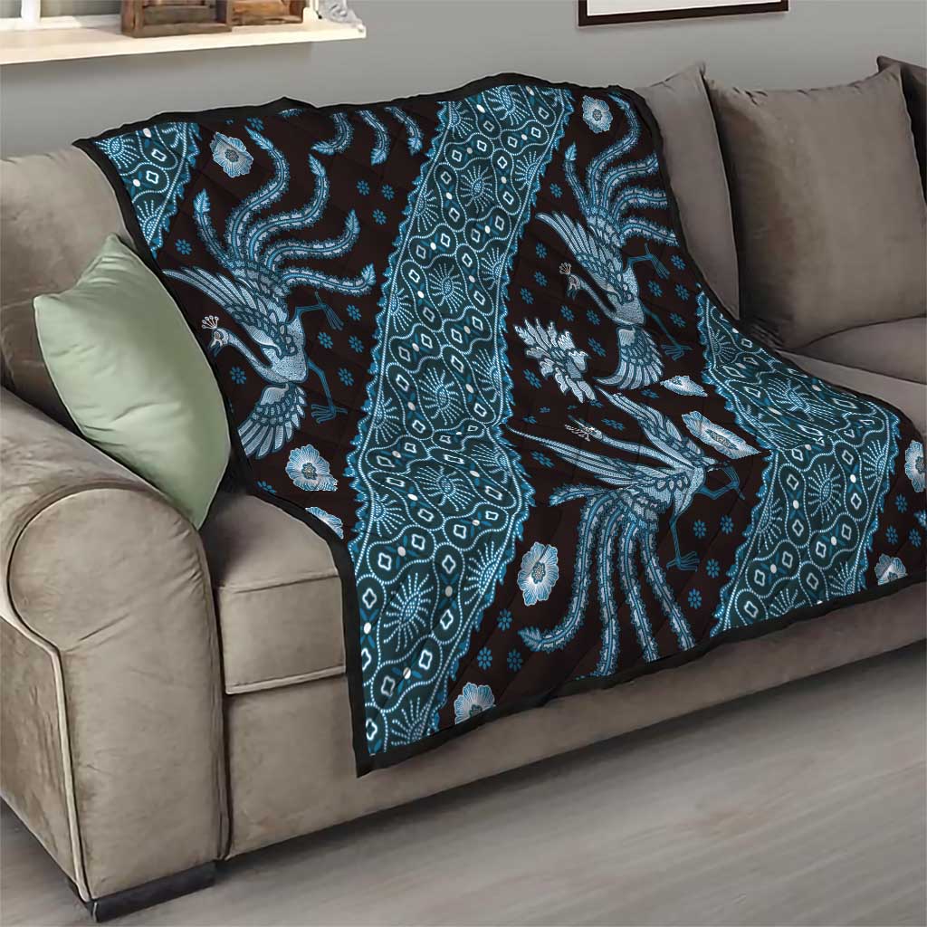 Blue batik pattern quilt draped on a sofa with dragon and diamond motifs