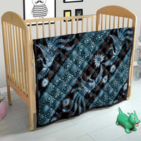 Blue batik pattern quilt on a wooden baby crib, dragon and floral medallion print