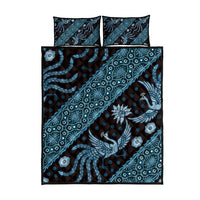 Blue batik quilt set with bird, floral, and geometric patterns on duvet and two pillows